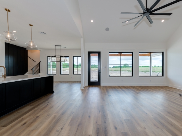 Unfurnished living room of the Wright Project with food flooring and black details.