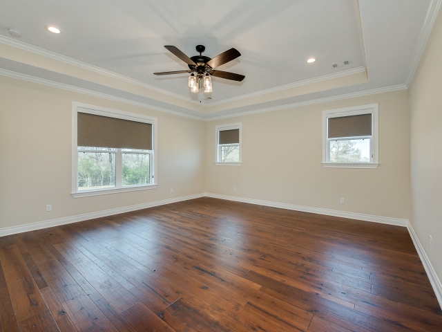 Bedroom with wood flooring and window features.