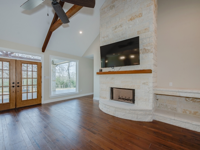 Living room of the Taylor Project by LaFollette Custom Homes with wood and stone details.