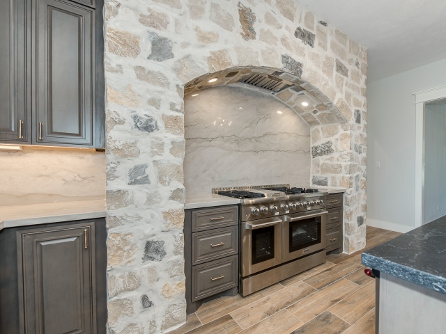 Kitchen of the Ball Circle Project by LaFollette Custom Homes with stone detailing.