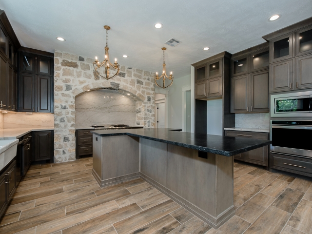 Kitchen of the Ball Circle Project with island featuring black countertops.