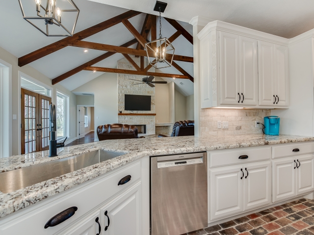 Kitchen of the Taylor Project by LaFollette Custom Homes with marble countertops and brick flooring.