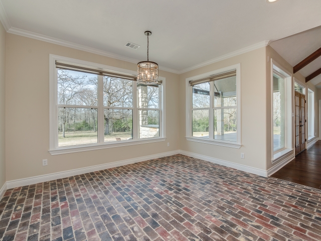 Dining room of the Taylor Project by LaFollette Custom Homes with brick flooring.