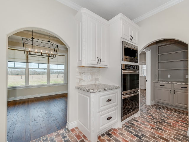 Kitchen of the Taylor Project by LaFollette Custom Homes with beautiful brick flooring.