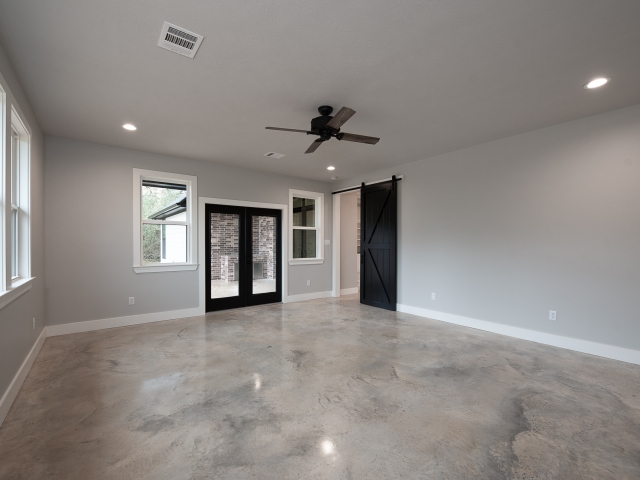 Bedroom with black sliding door and large windows.