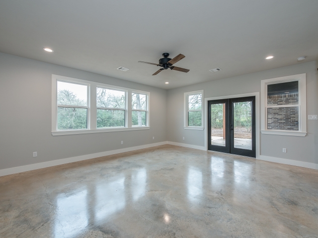 LaFollette Custom Homes bedroom with windows and concrete flooring.
