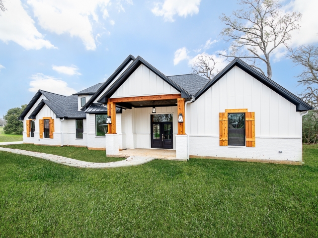 The Roznovsky Project by LaFollette Custom Homes with a white exterior and black &amp; wood accents.