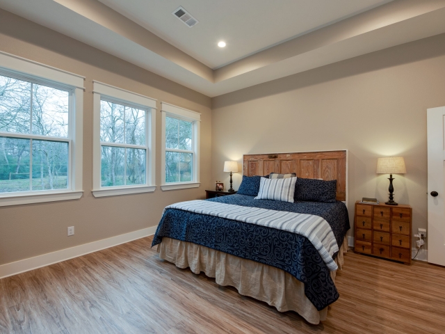 LaFollette Custom Homes bedroom with windows and a high ceiling.