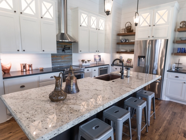 Kitchen of the Chisam Project by LaFollette Custom Homes featuring white cabinets and a marble countertop island.