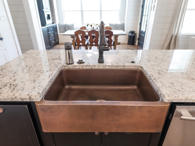 Stunning copper sink and marble countertops in the Chisam Project&#039;s kitchen.