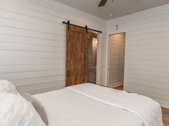 Bedroom with clean white aesthetic and sliding barn door.