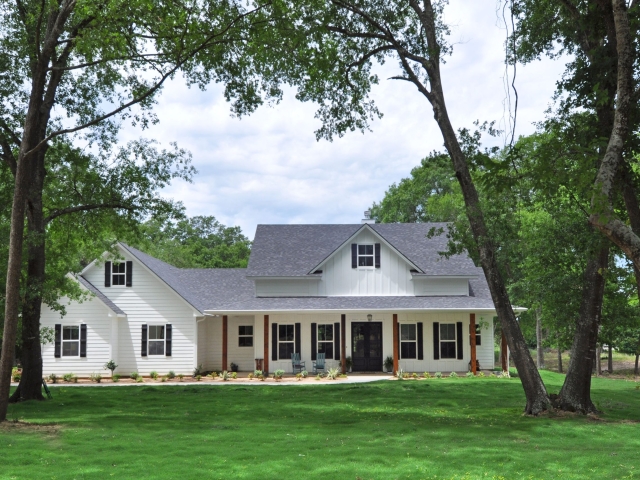The Moore Project by LaFollette Custom Homes with a white exterior and wood accents.