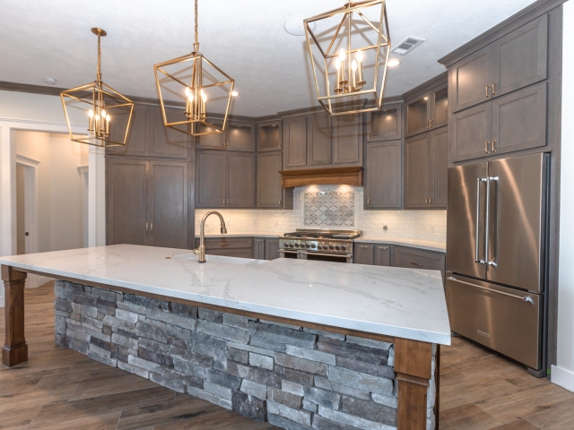 Millican Project kitchen by LaFollette Custom Homes featuring grey stonework and large island.