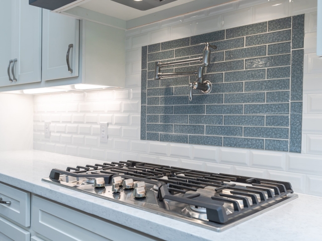 Stovetop from the Bishop Project by LaFollette Custom Homes with sink installation and backsplash.