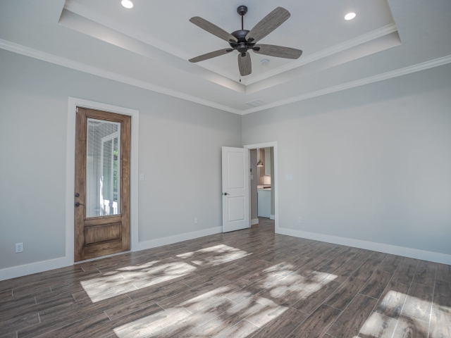 Bedroom with natural lighting and wood floors.