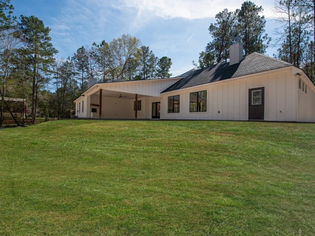 The Bodner Project with white exterior overlooks a lush lawn.