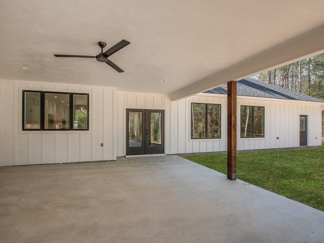 White back porch of the Bodner Custom Home with industrial fan and wood detailing.