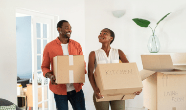 A couple moving boxes into their new custom home.