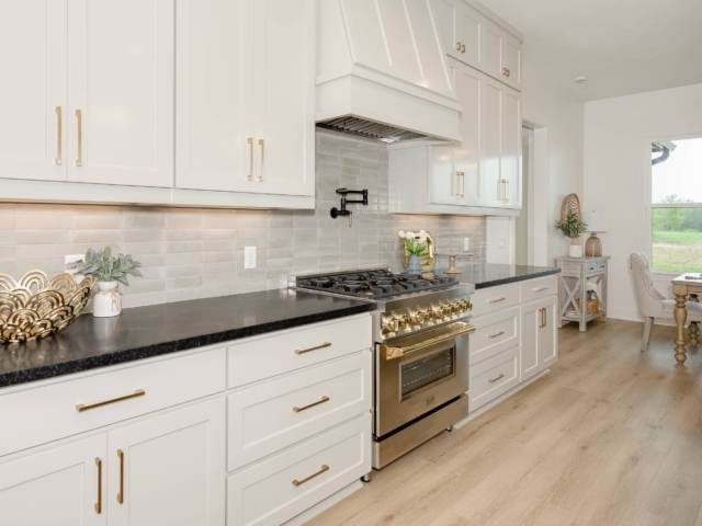Kitchen of the Lakecrest Project by LaFollette Custom Homes with gold detailing and appliances.
