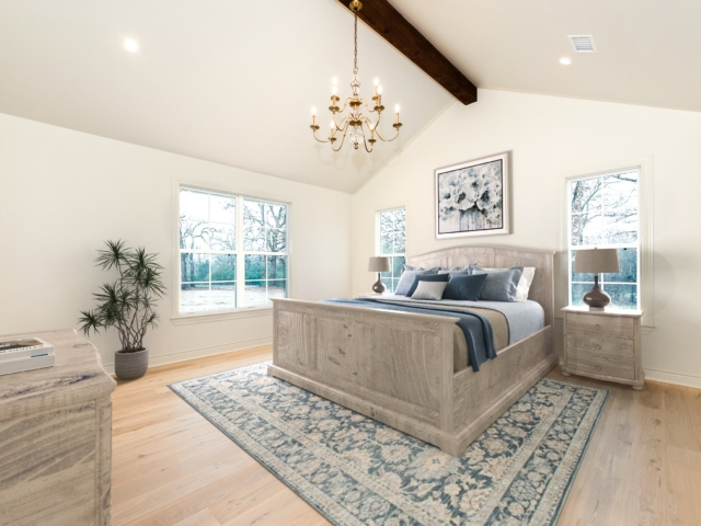 Bedroom with wood flooring and high ceilings.