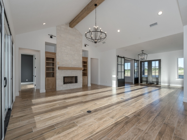 Unfurnished living room of the Berryman Project by LaFollette Custom Homes featuring stunning wood flooring.