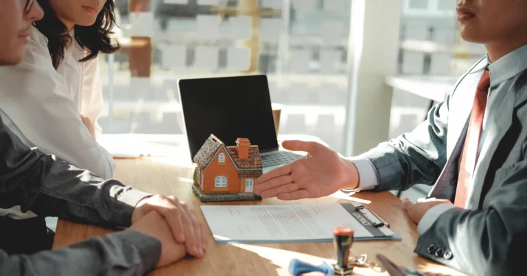 Hand reaching out for a handshake over a wooden table, talking over building your dream home: timeline & what to expect