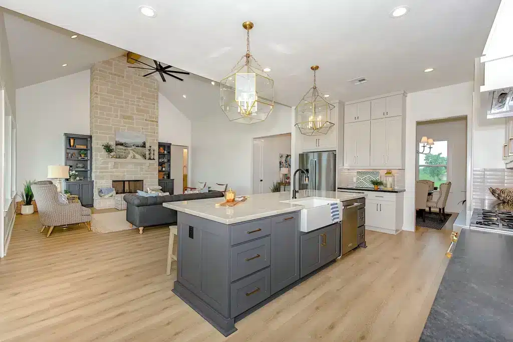 Current image: Modern white kitchen with grey-blue cabinets, beige wood flooring, fixed round ceiling lights, and sleek white countertops.